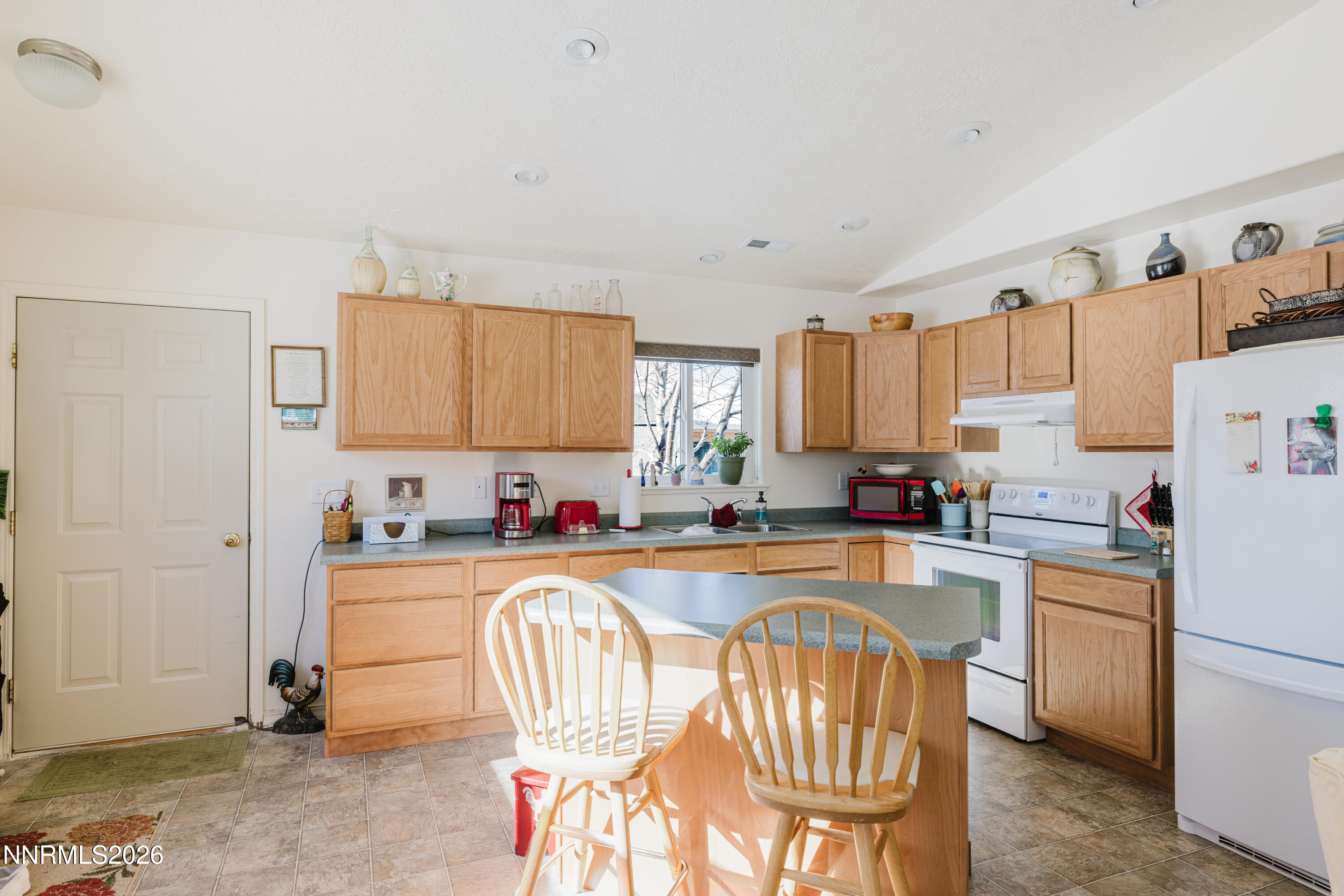 2013 Blume Ranch Road Lamoille, NV 89828 - Photo 28 of 37 a kitchen with a refrigerator a stove a sink dishwasher and white cabinets with wooden floor
