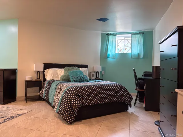 a bedroom with a bed and a flat tv screen on dresser