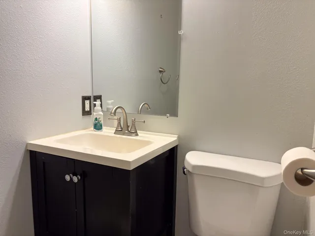a bathroom with a sink a toilet and a mirror