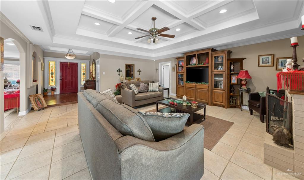 1514 Walnut Court Harlingen, TX 78550 - Photo 5 of 24 Living area featuring arched walkways, crown molding, ceiling fan, recessed lighting, and coffered ceiling
