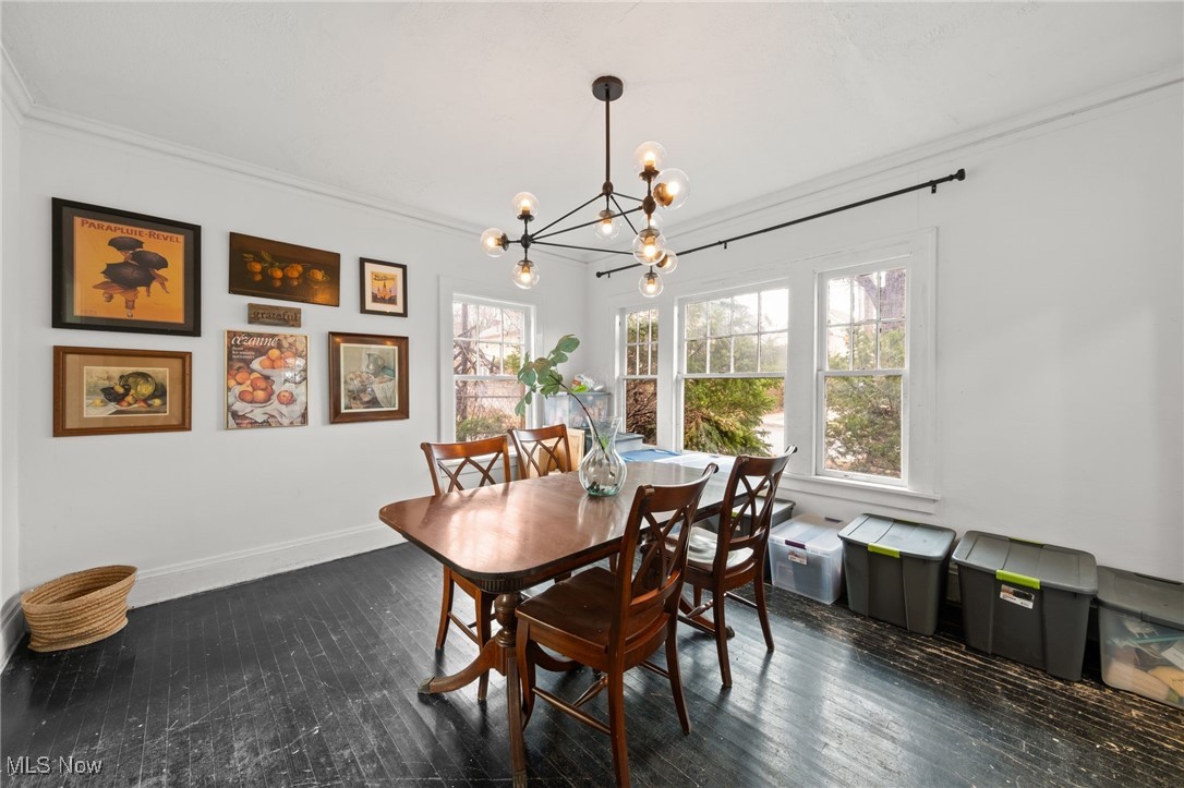 1857 Willowhurst Road Cleveland, OH 44112 - Photo 26 of 26 Dining area with dark wood-type flooring, a notable chandelier, and ornamental molding