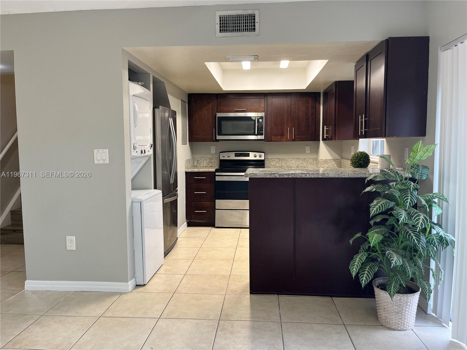 5150 Lake Loop Road Cooper City, FL 33330 - Photo 7 of 22 a kitchen with stainless steel appliances kitchen island granite countertop a refrigerator and a sink