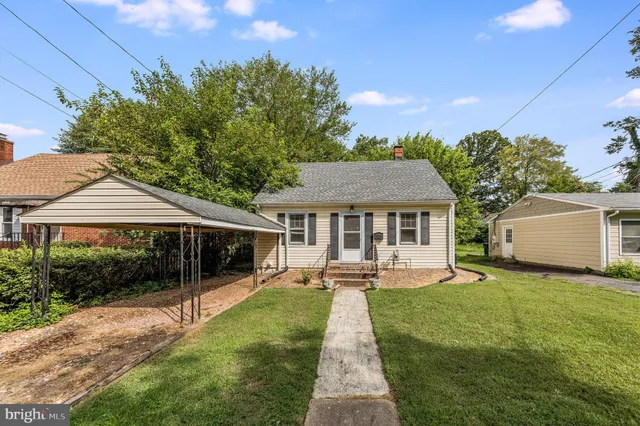 a front view of a house with a yard and trees