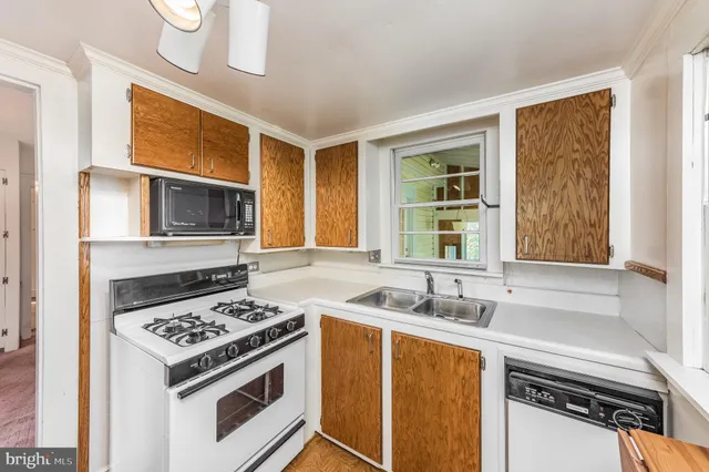 a kitchen with stainless steel appliances a stove a sink and a microwave