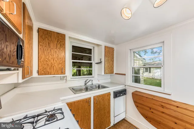 a view of a kitchen with a sink and dishwasher next to a window