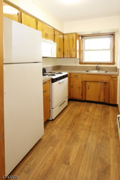 2 Westervelt Place, Unit C203 Clifton, NJ 07011 - Photo 5 of 11 a view of a kitchen with a stove top oven