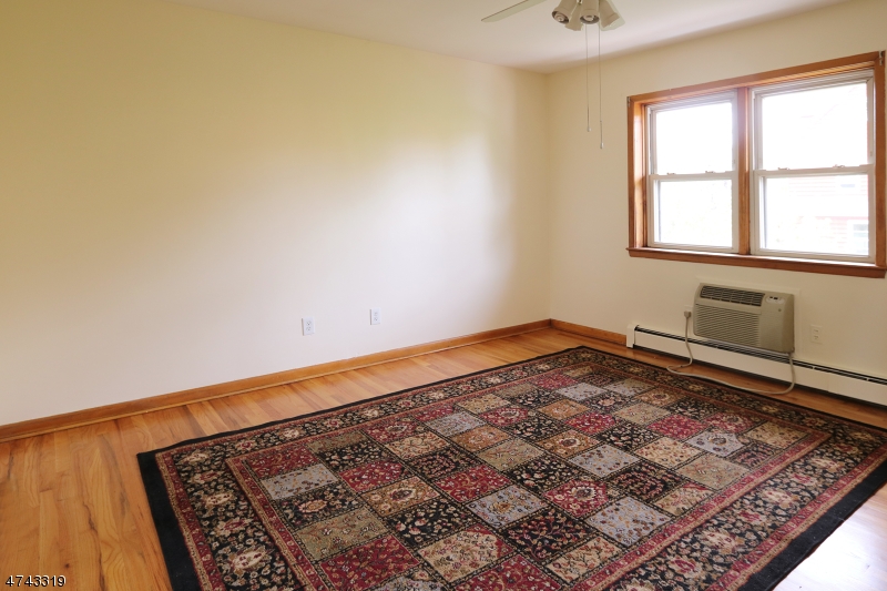 2 Westervelt Place, Unit C203 Clifton, NJ 07011 - Photo 7 of 11 an empty room with a rug