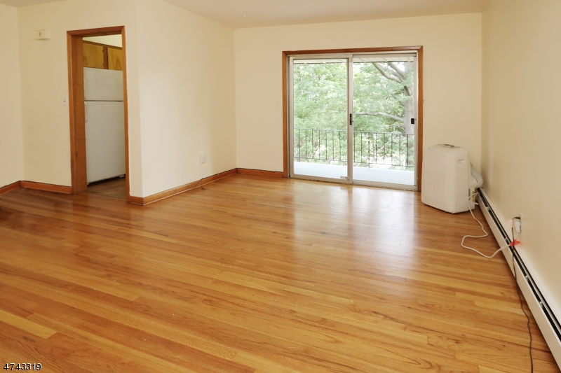 2 Westervelt Place, Unit C203 Clifton, NJ 07011 - Photo 8 of 11 a view of an empty room with wooden floor and a window