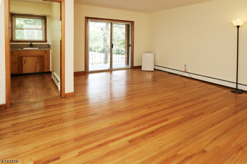 2 Westervelt Place, Unit C203 Clifton, NJ 07011 - Photo 9 of 11 a view of an empty room with wooden floor and a window