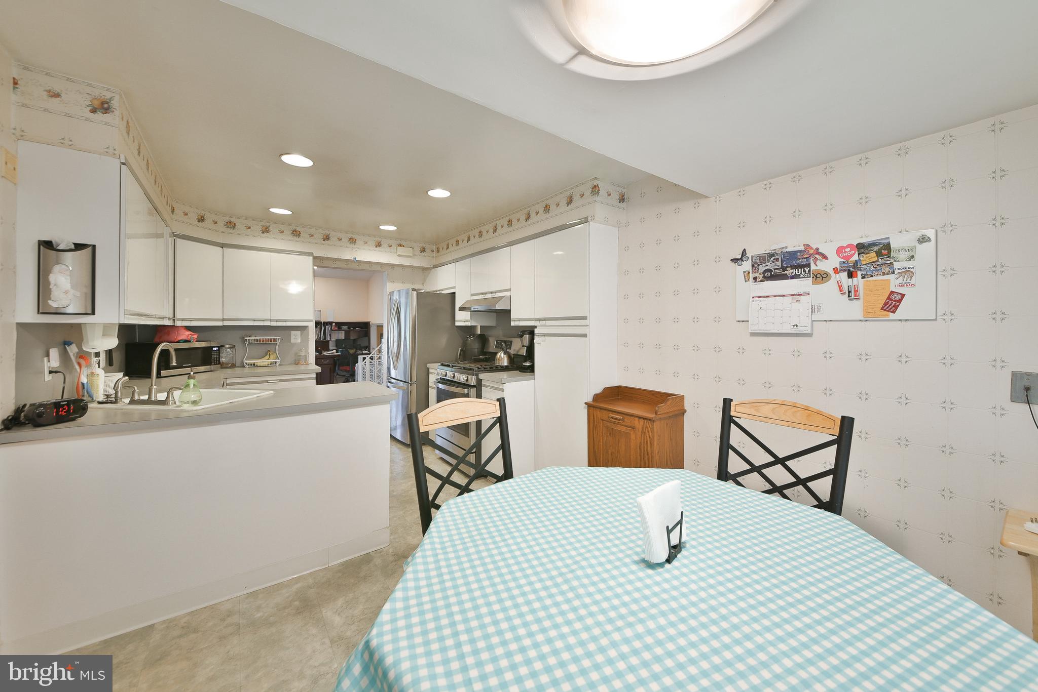 1035 Old Ford Road Huntingdon Valley, PA 19006 - Photo 12 of 39 a kitchen with stainless steel appliances kitchen island granite countertop a refrigerator a sink a stove a dining table and chairs with wooden floor