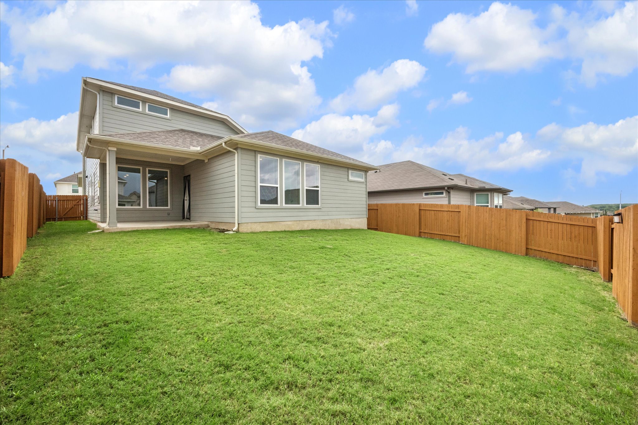 6407 Rounded Pebble Lane Buda, TX 78610 - Photo 30 of 32 A spacious backyard with vibrant green grass and a privacy fence.