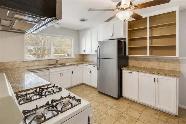 a kitchen with a stove a refrigerator and a sink