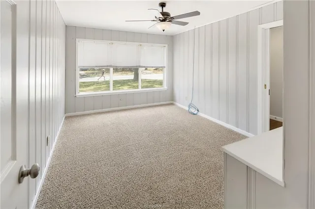 a view of a livingroom with a ceiling fan and window