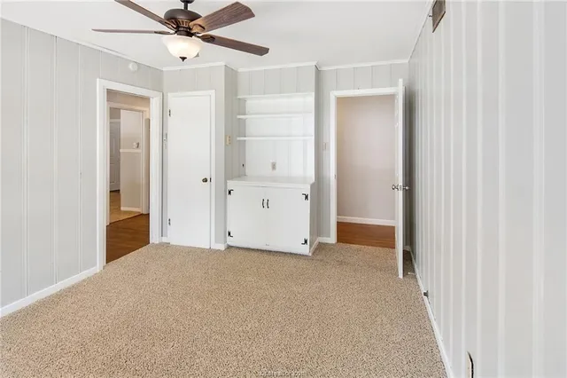 a view of a big room with a chandelier fan and a bathroom