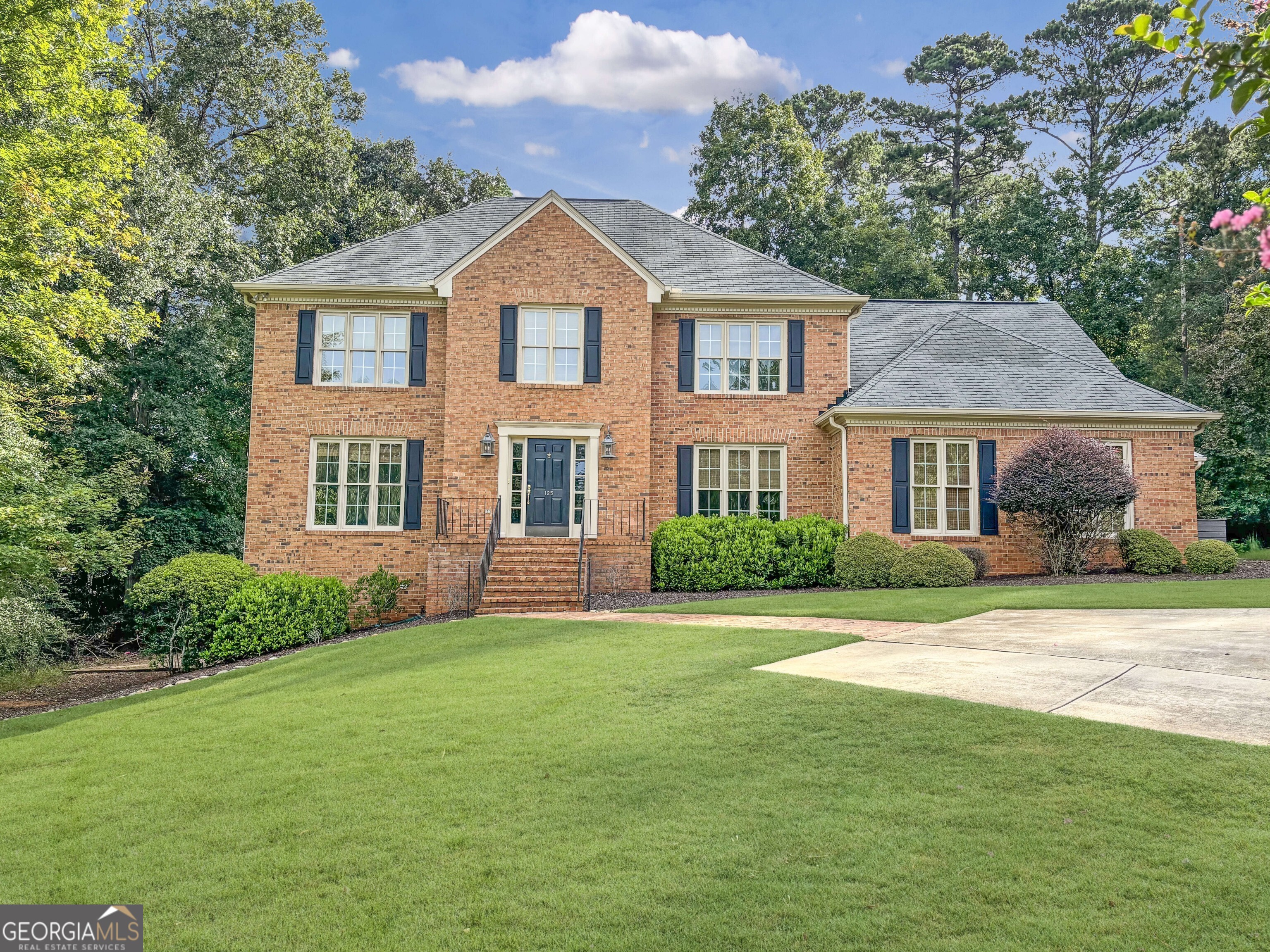 a front view of a house with a garden