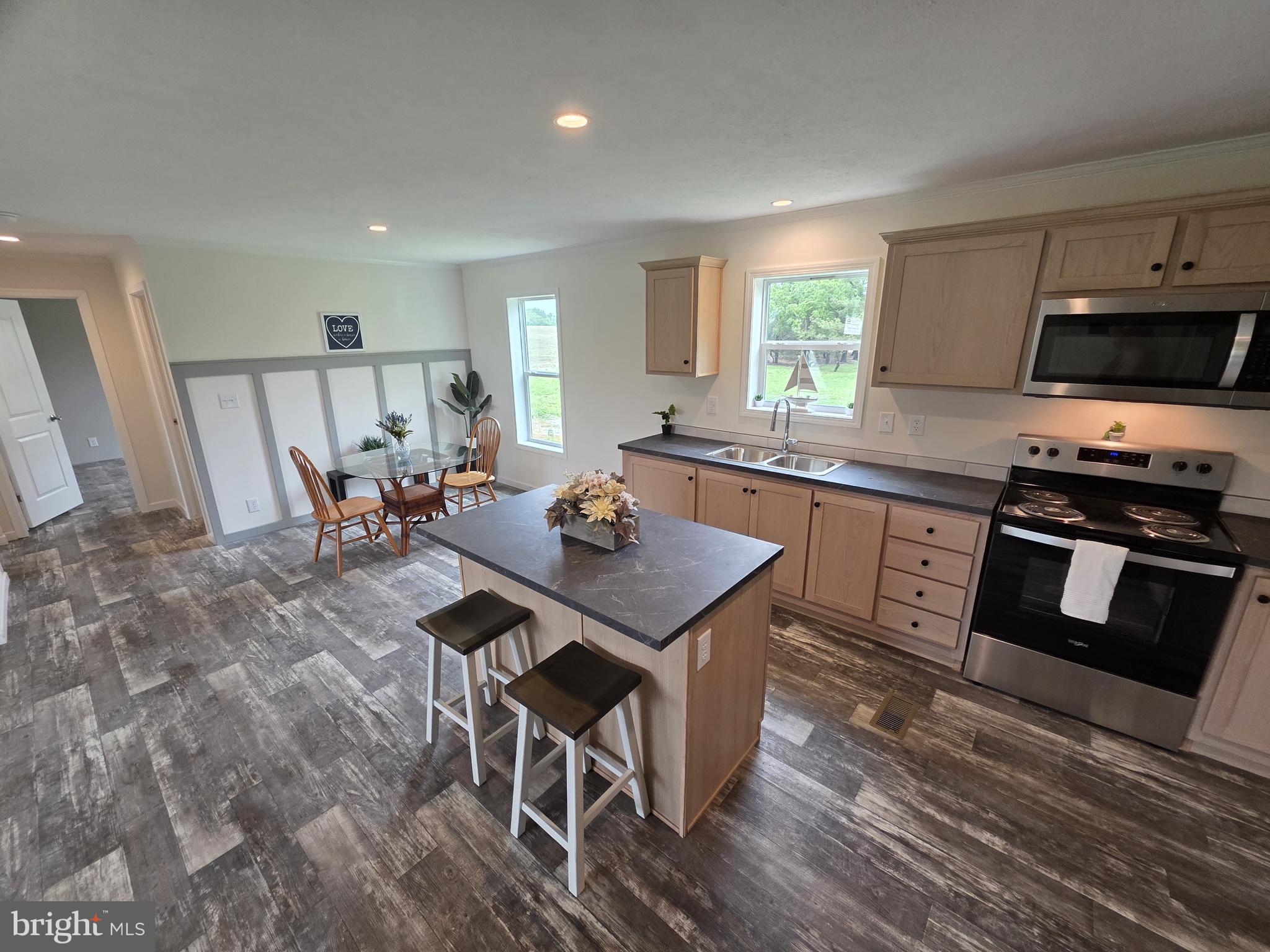 289 Grove Neck Road Earleville, MD 21919 - Photo 6 of 19 a kitchen with stainless steel appliances granite countertop a stove top oven a sink dishwasher a dining table and chairs with wooden floor