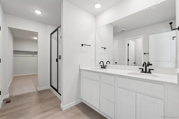 a bathroom with a double vanity sink mirror and shower