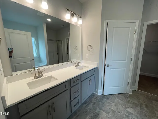 a bathroom with a sink double vanity and a mirror