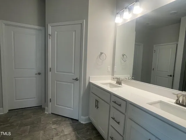 a bathroom with a double vanity sink and a mirror