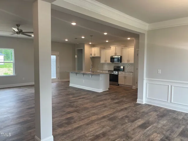 a view of a kitchen with cabinets and wooden floor