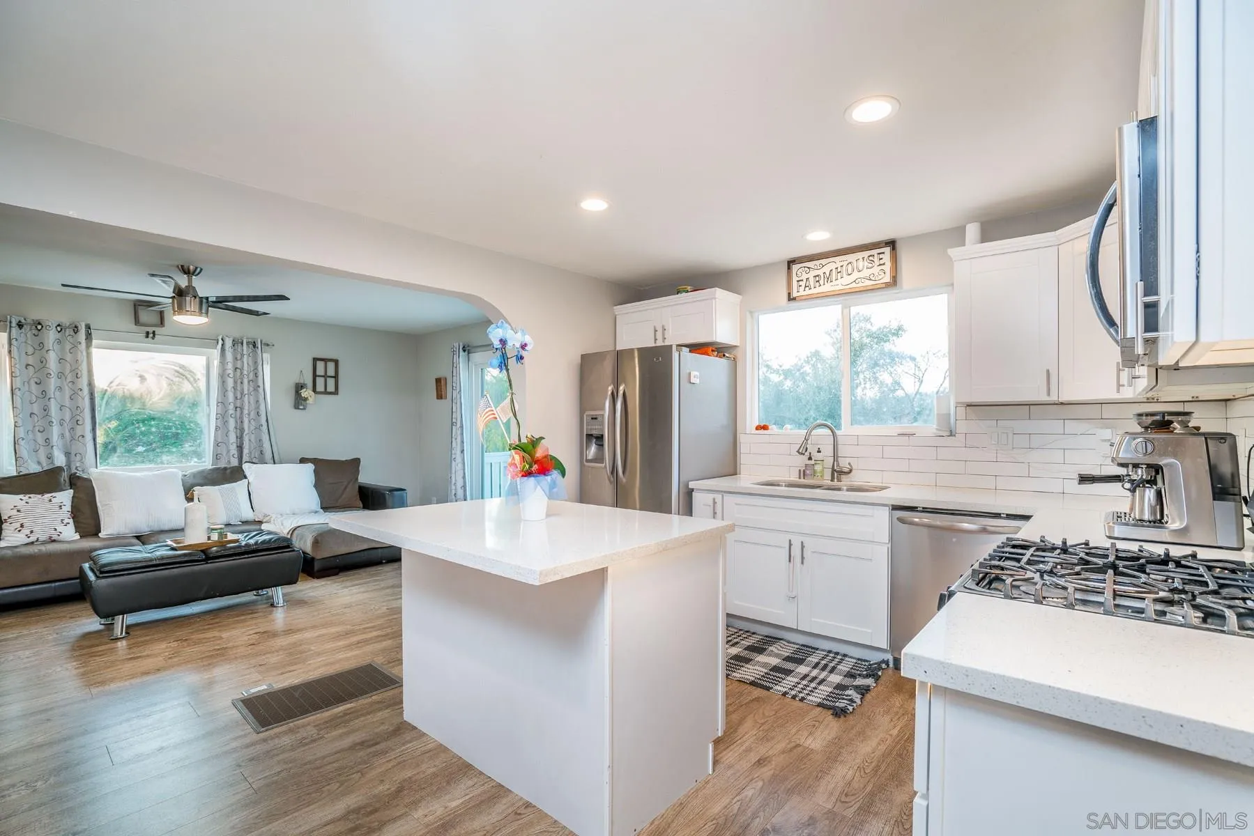 9206 Lamar Street Spring Valley, CA 91977 - Photo 7 of 21 a large white kitchen with a stove a sink a dining table and chairs