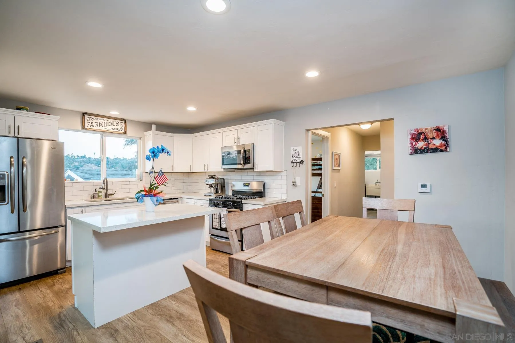 9206 Lamar Street Spring Valley, CA 91977 - Photo 8 of 21 a large kitchen with sink a refrigerator and chairs