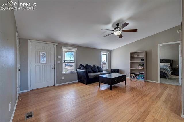 5860 Curtis Road Peyton, CO 80831 - Photo 9 of 28 Living area with vaulted ceiling, visible vents, light wood finished floors, and ceiling fan