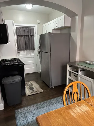 a kitchen with stainless steel appliances granite countertop a refrigerator a stove and a sink with wooden floor