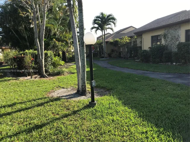 a view of a house with a backyard and a tree