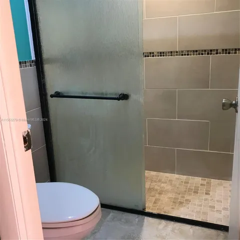 a bathroom with a toilet and a shower