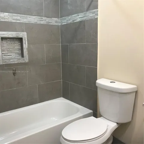 a white toilet and tub sitting next to a bathroom sink