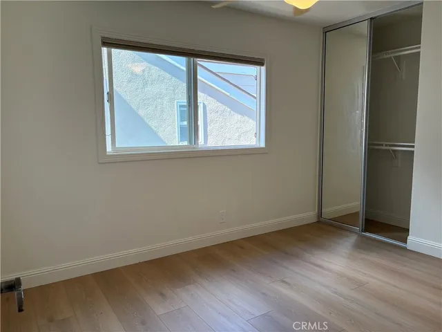 an empty room with wooden floor and cabinet