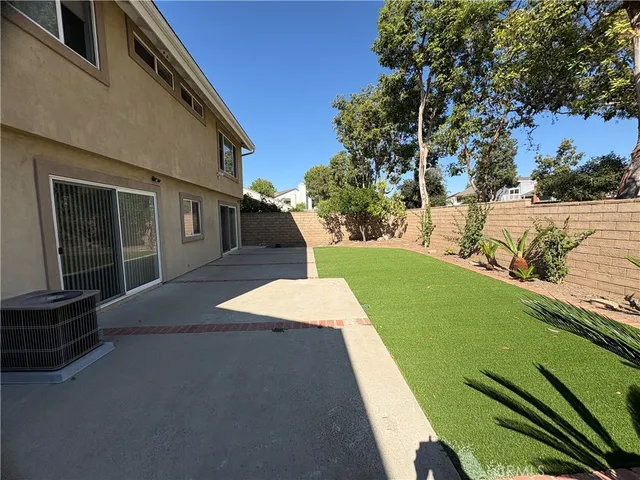 an aerial view of a house with a yard and large tree