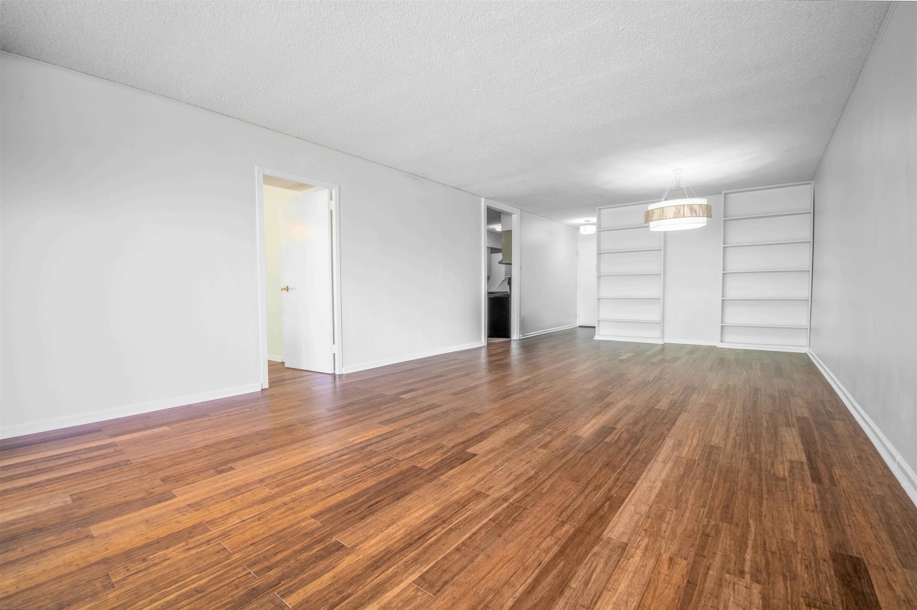 3080 Walnut Grove Road, Unit 306 Memphis, TN 38111 - Photo 4 of 18 Expansive room featuring wood-finish flooring, white walls, and built-in shelving
