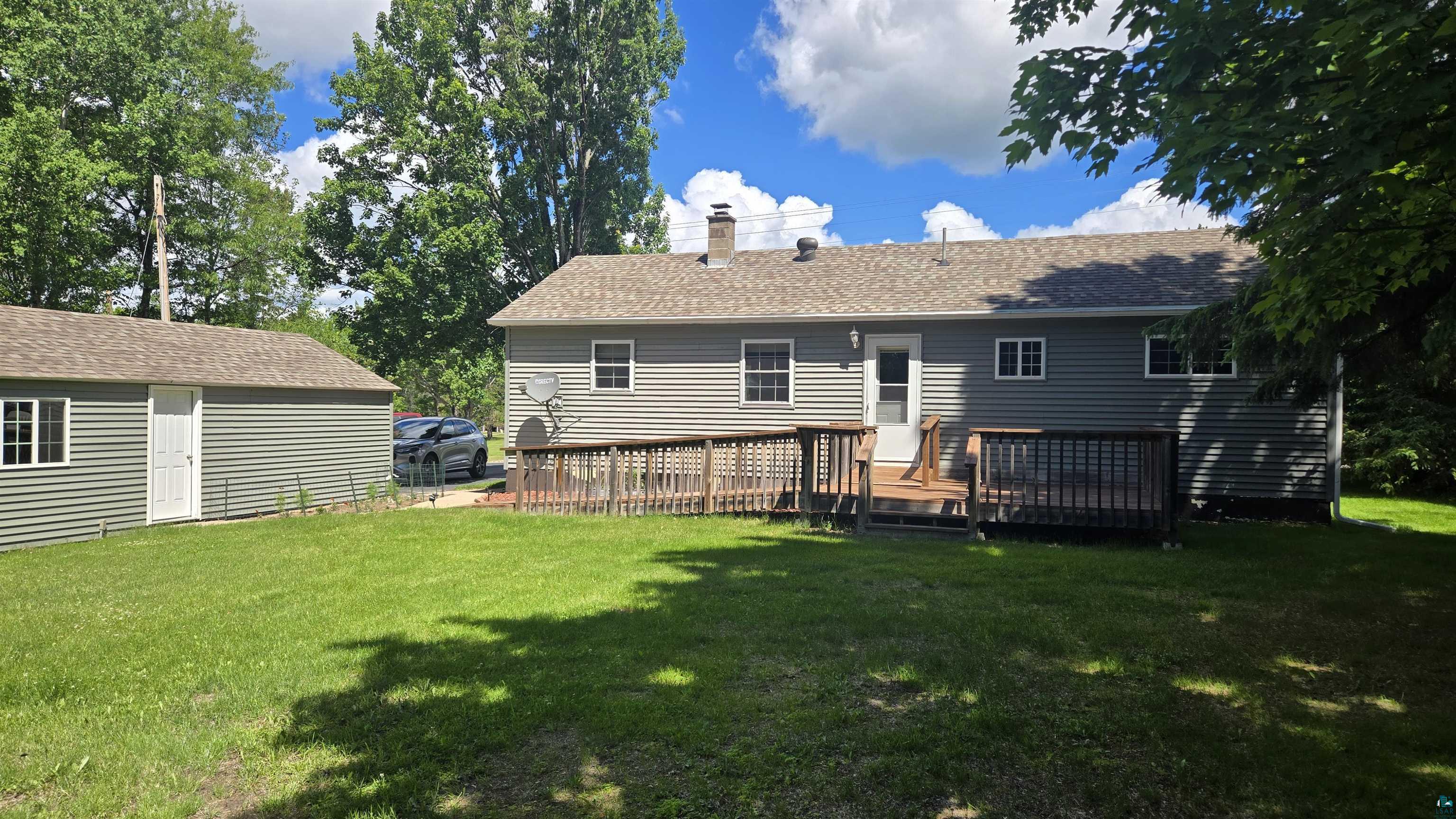 10614 Moose Lake Road Orr, MN 55771 - Photo 4 of 44 Expansive backyard featuring a manicured lawn, a detached storage shed, a wood deck, and a ramp for accessibility