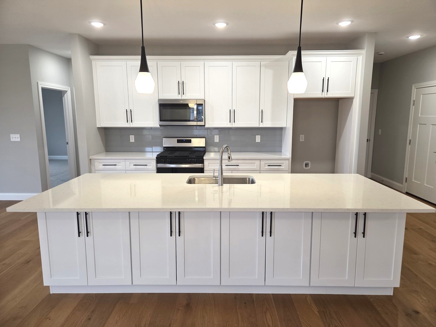 3 Saint Ivans Circle Bloomington, IL 61705 - Photo 3 of 29 a kitchen with kitchen island granite countertop a sink a stove a refrigerator and white cabinets with wooden floor