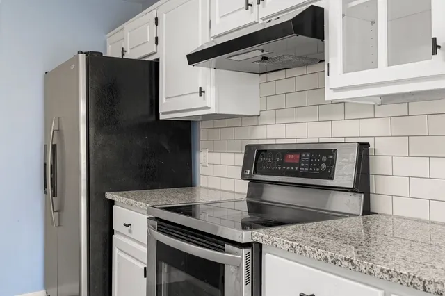 a kitchen with granite countertop cabinets and steel stainless steel appliances