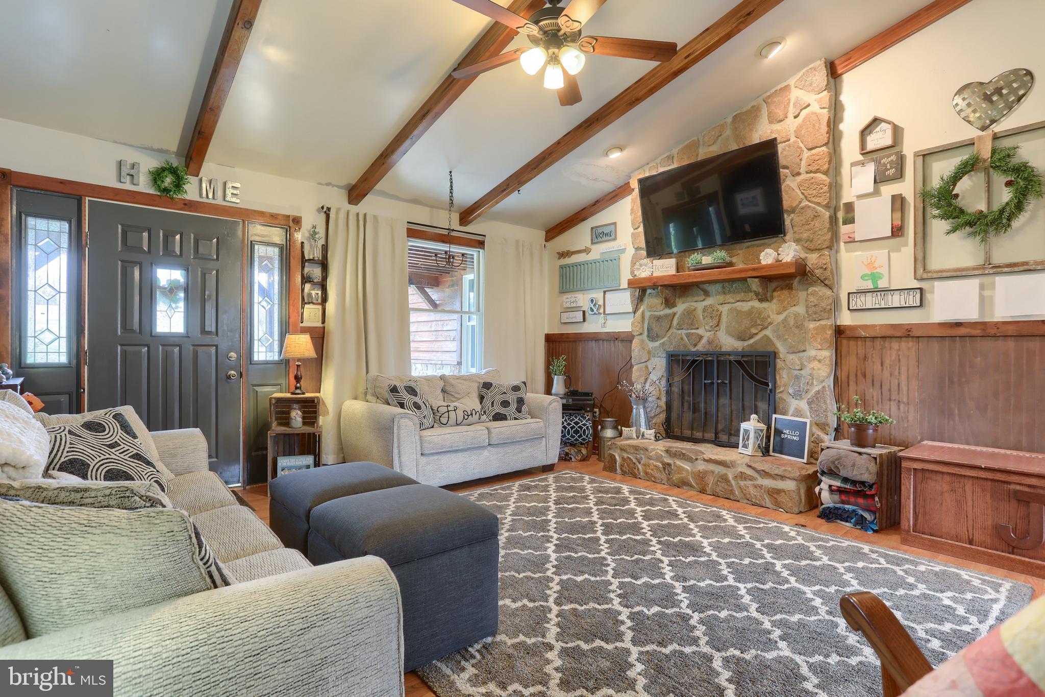 living room w exposed beams and fireplace
