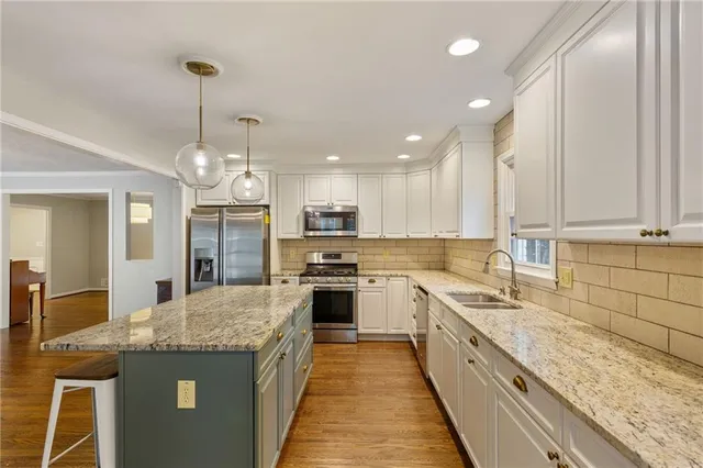 a large kitchen with granite countertop a stove top oven a sink a counter space and cabinets