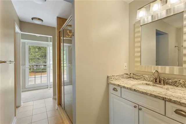 a bathroom with a granite countertop sink and a mirror