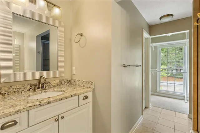 a bathroom with a granite countertop sink a mirror and a shower