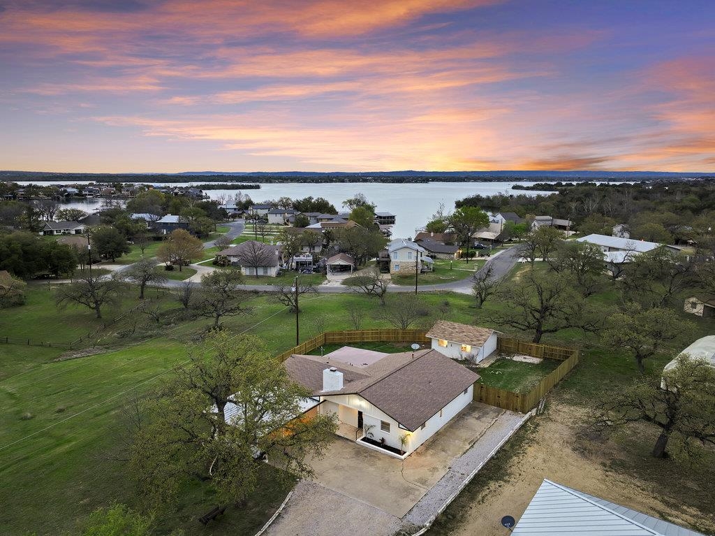 an aerial view of a house with yard and lake view