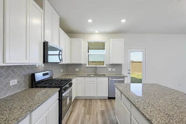 a kitchen with a sink stove and cabinets