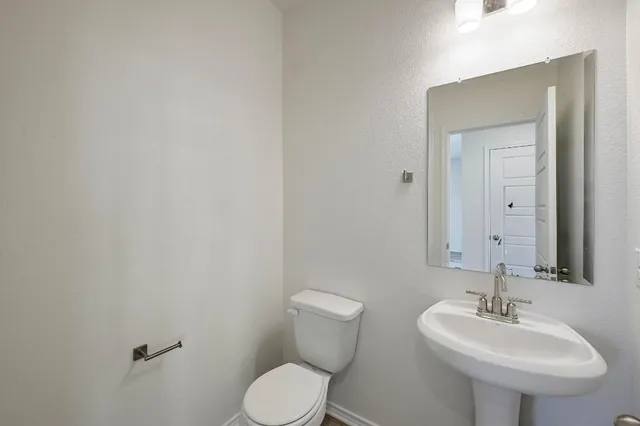 a bathroom with a sink a toilet and mirror