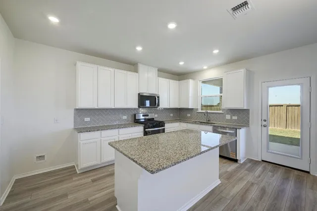 a kitchen with a sink stove and cabinets