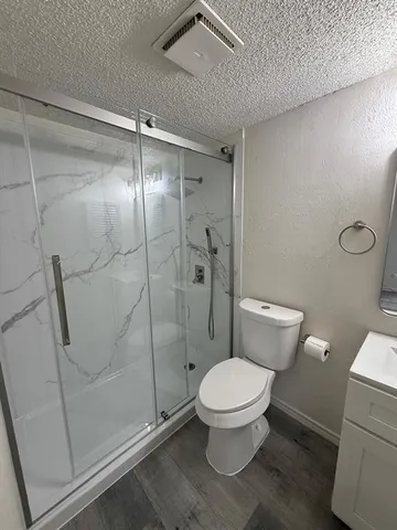 a white toilet sitting next to a shower