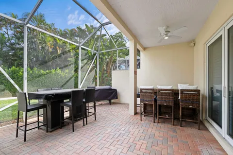 a view of a patio with table and chairs with wooden floor and floor to ceiling window