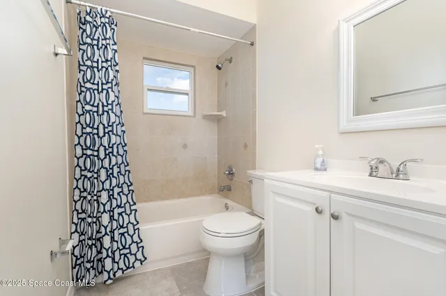 a bedroom with a bed a table and large window