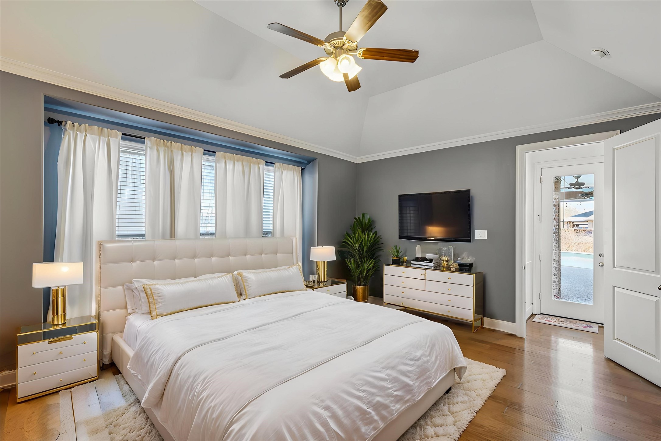 29918 Valley Terrace Drive Fulshear, TX 77406 - Photo 12 of 27 The spacious primary suite, conveniently located on the first floor with direct access to the backyard covered patio and pool area, features high vaulted ceilings and large windows with custom drapes allow for plenty of natural light.