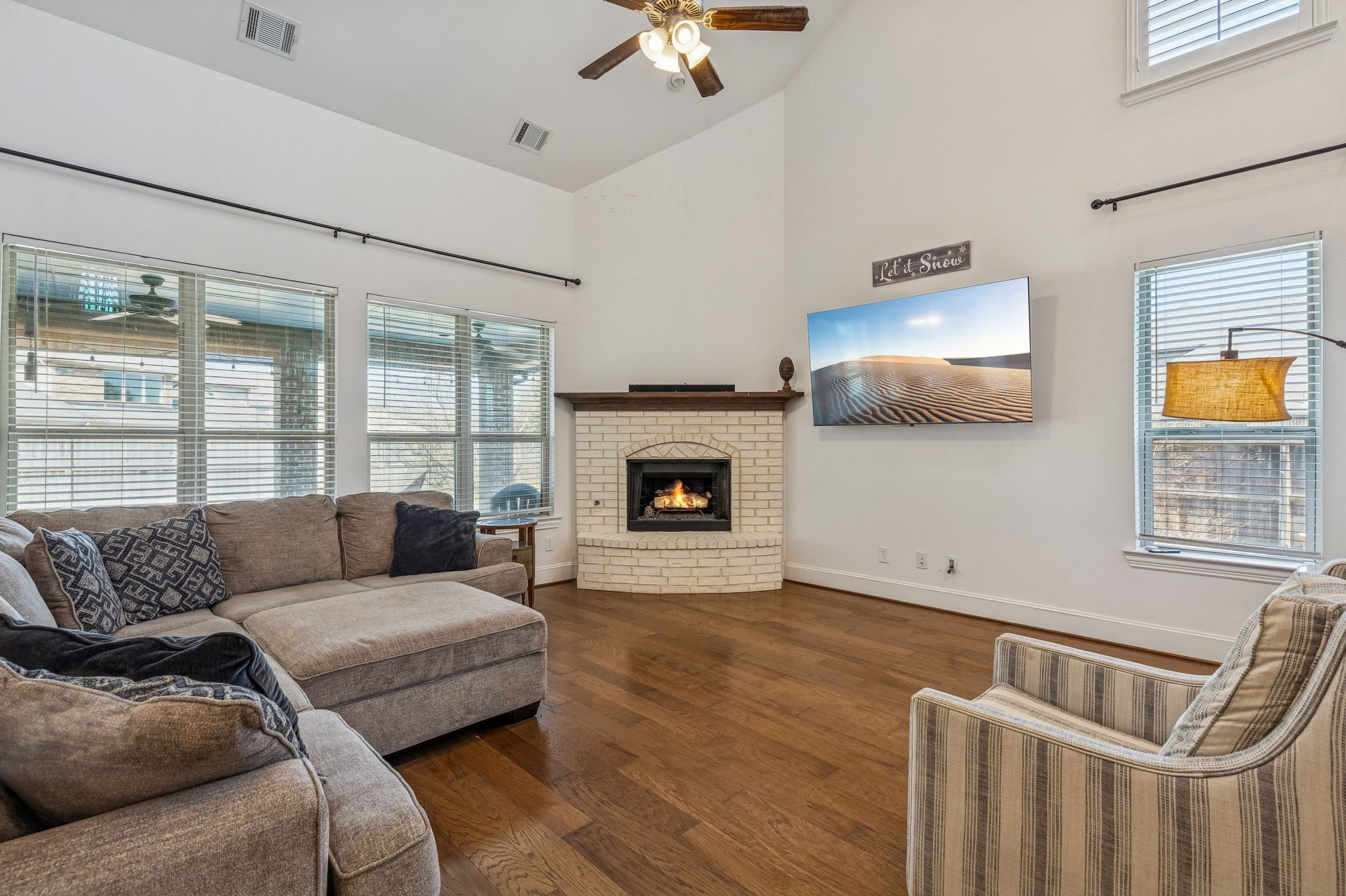 29918 Valley Terrace Drive Fulshear, TX 77406 - Photo 5 of 27 The heart of the home features a cozy gas log fireplace with a classic white brick surround. Large windows invite an abundance of natural light in this large living room.